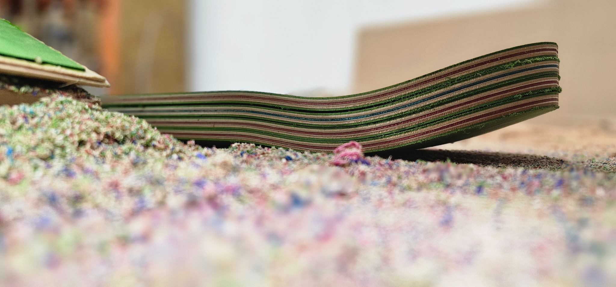 Pressed skateboard deck showing multiple colored veneer layers