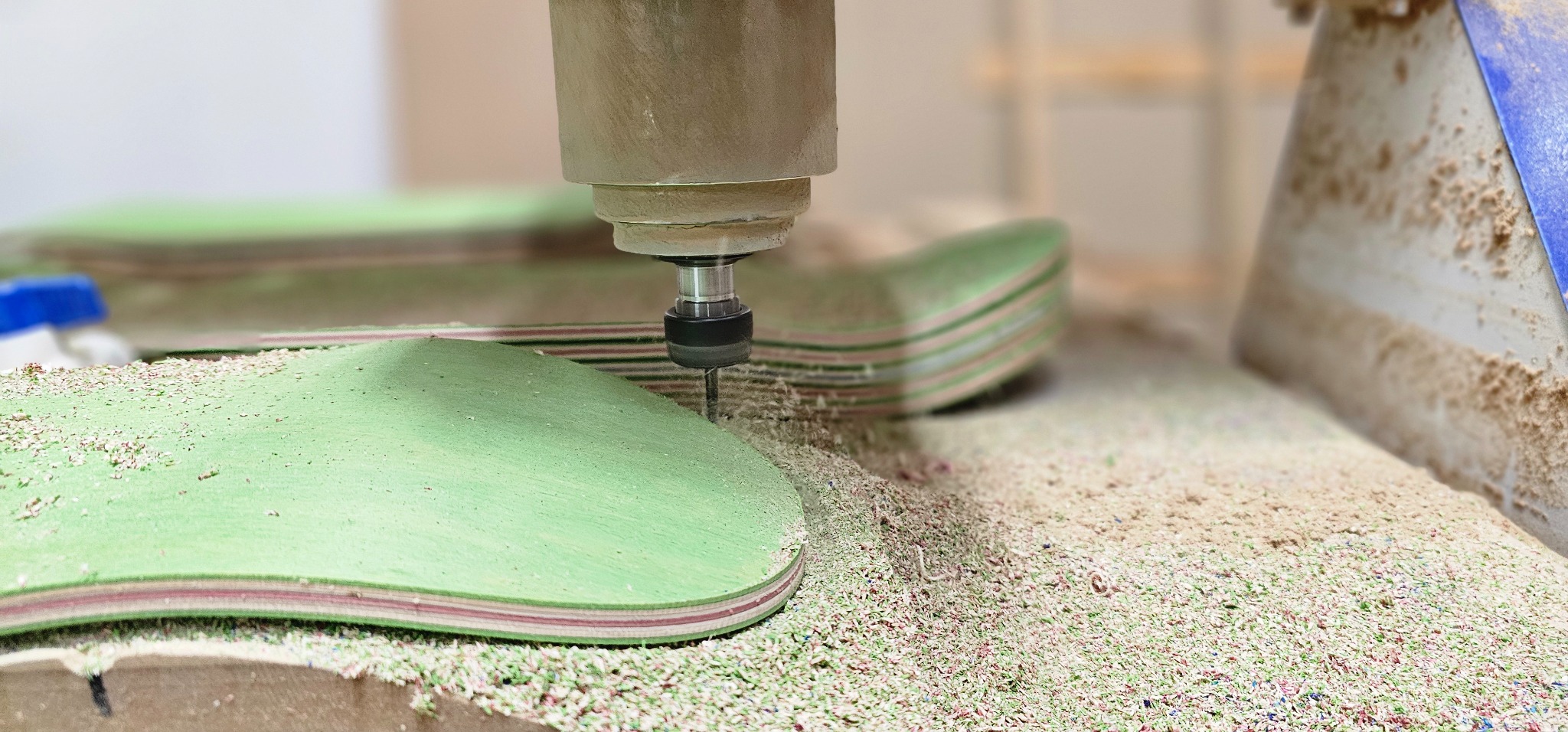 CNC trimming a skateboard tail using a production jig